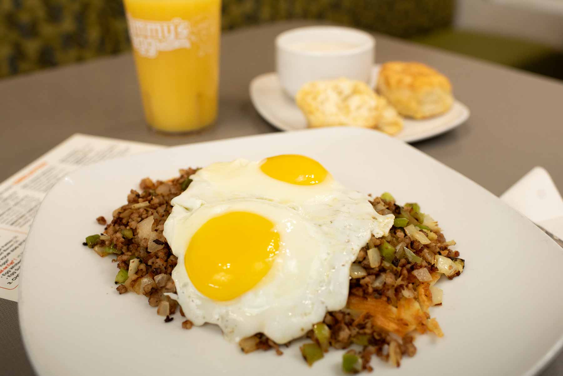 Garbage Breakfast meal with hash browns, onions, bell peppers, crumbled sausage, and two eggs at Jimmy's Egg.