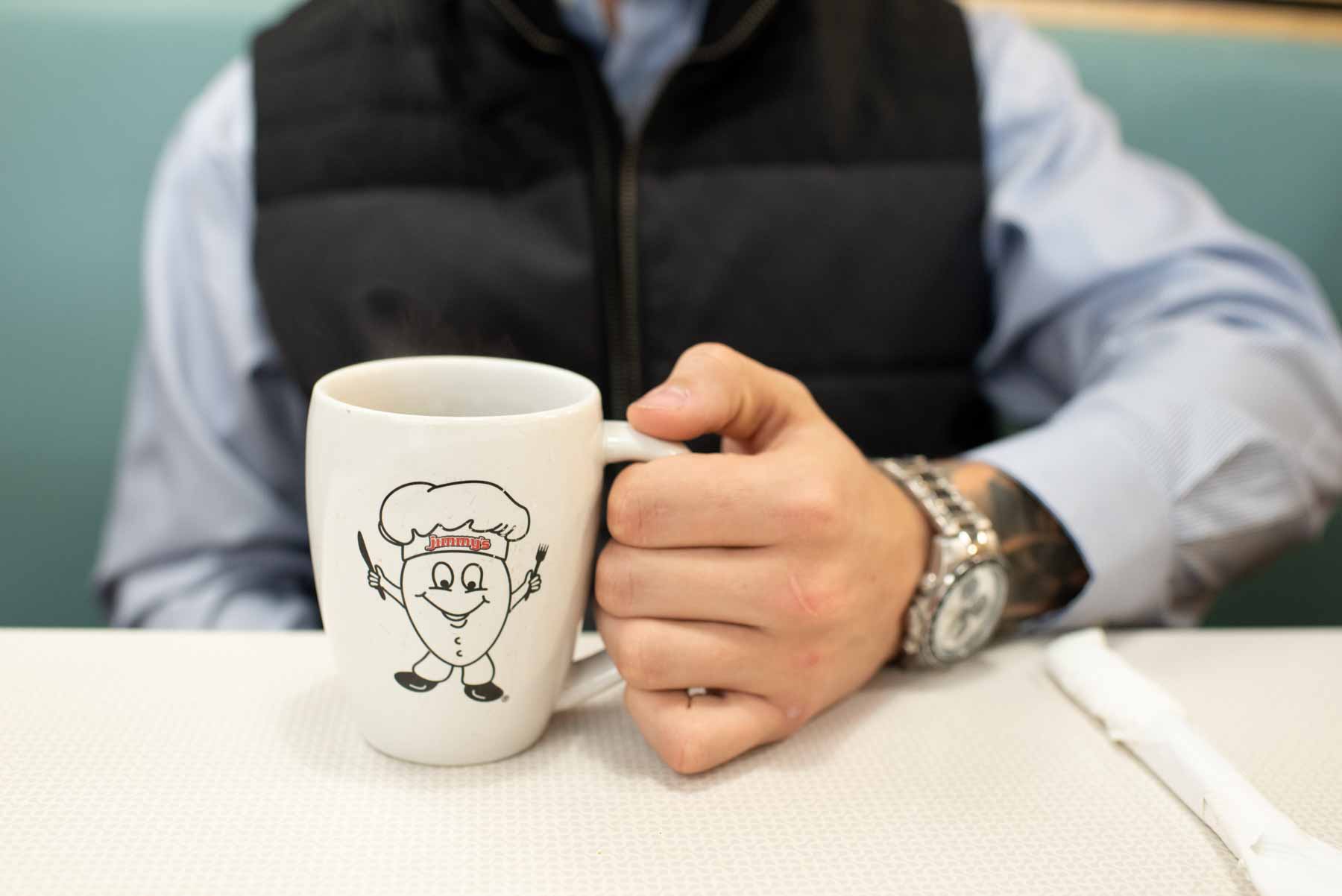 Male Holding a Jimmy's Egg Coffee Mug