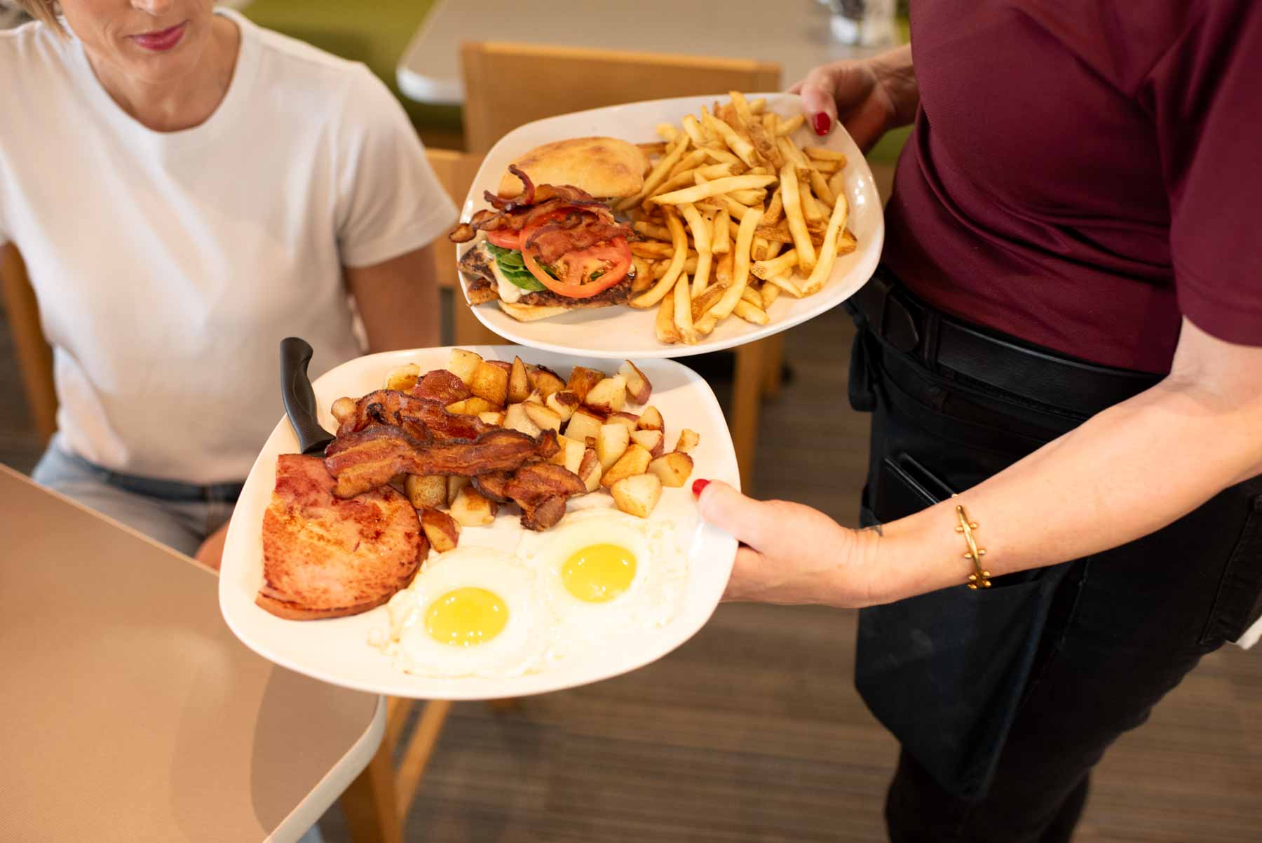 A Jimmy's Egg server serving breakfast and lunch to a guest.